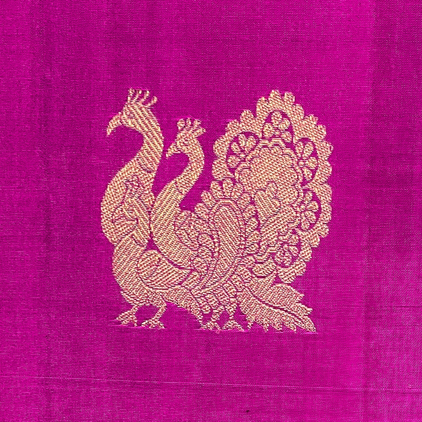 Gold peacock design on a pink fabric background